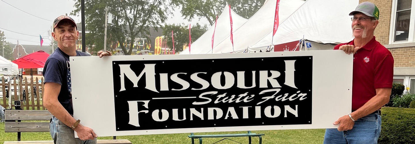 Two men holding the foundation office sign