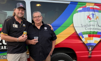 A Foundation member and a business partners outside the partner's van at an event for the foundation