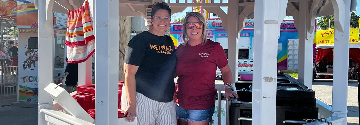 Two volunteers selling water at a gazebo at the Fairgrounds